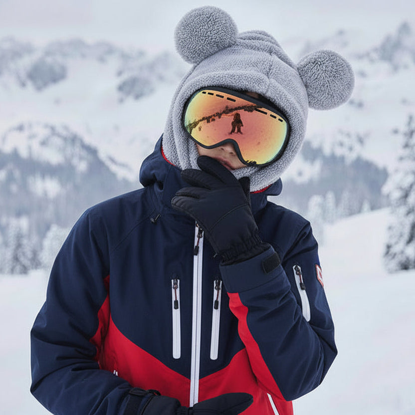 Person in winter gear with a snowy mountain background
